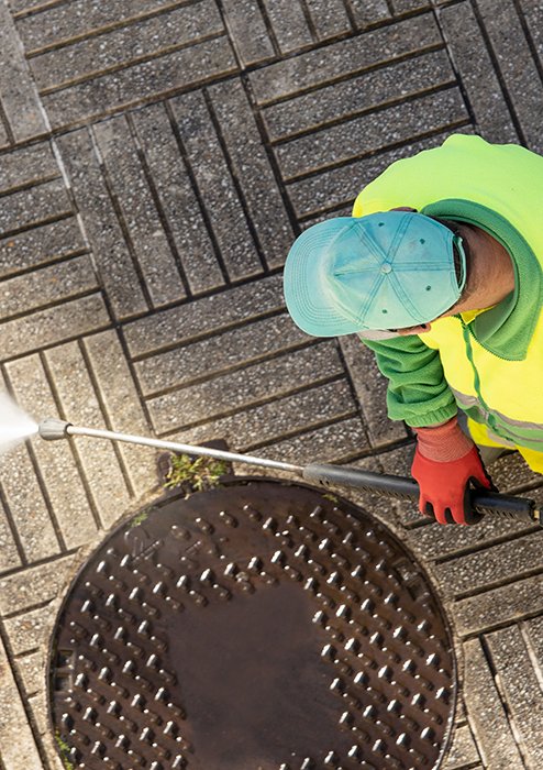 worker-cleaning-a-street-sidewalk-with-high-pressu-2023-11-27-05-09-41-utc
